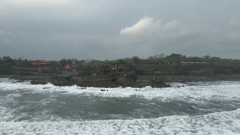 Niedrige-Küstenluftaufnahmen-Nähern-Sich-Dem-Nebligen-Tanah-Lot-Hindu-Tempel-Auf-Bali