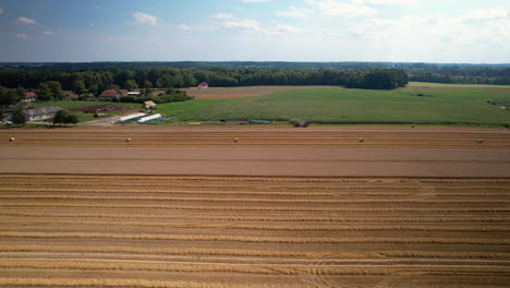 A-View-of-Gathering-Crops-in-the-Field,-Poland---Pullback-Aerial