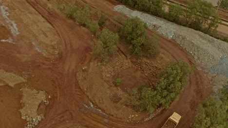 Low-aerial-view-of-dump-trucks-moving-tonnes-of-Nickel-rich-ore-around-a-mining-site-in-Taganito