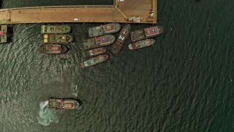 Top-down-aerial-view-of-Tug-boats-moored-at-the-pier-in-Taganito-waiting-to-assist-Nickel-Asia-mining-barges