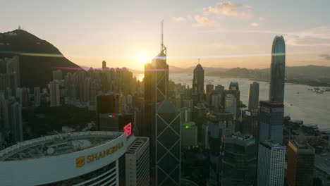Aerial-establishing-drone-shot-of-downtown-Central-Financial-district-with-Shangri-la-Hotel-in-Hong-Kong-City-during-golden-sunset-at-horizon