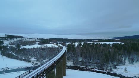 Aerial-shot-of-historic-single-track-rail-bridge-over-valley-with-river