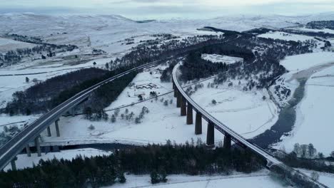 Aerial-view-of-railway-and-motorway-bridges-spanning-wide-valley-with-River-Findhorn