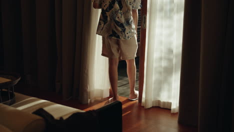 Teen-man-from-camera-walk-out-hotel-villa-room-using-sliding-door-on-vacation-holiday
