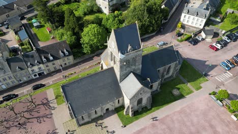 Church-in-centre-with-paratrooper-suspended-from-tower-Sainte-Mere-Eglise-Normandy-France-drone,aerial