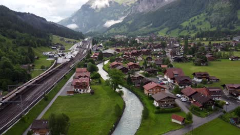 Aerial-Townscape-of-Kandersteg-town-in-Switzerland,-a-Swiss-alpine-Village-in-a-Valley-amid-green-Meadows-and-alps-mountains