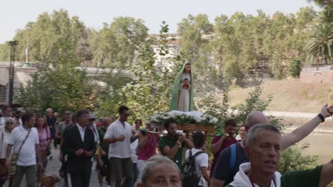 Religiöse-Prozession-In-Rom-Entlang-Der-Ufer-Des-Flusses-Tiber,-Eine-Statue-Der-Madonna,-Maria,-Der-Mutter-Jesu-Christi,-Wird-Von-4-Männern-Getragen