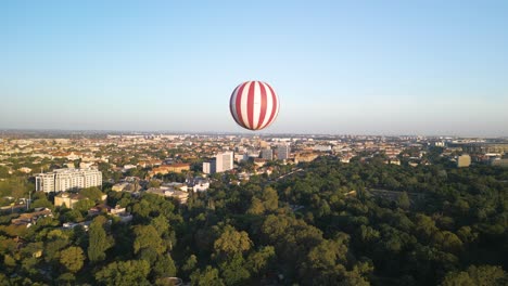Luftumlaufende-Drohnenaufnahme-Eines-Roten-Und-Weißen-Ballons,-Der-Im-Budapester-Stadtpark-Ballont