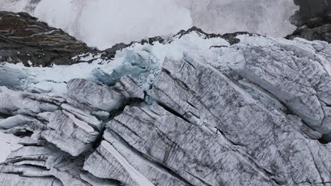 Drone-flying-over-wall-of-ice-and-rock-of-Fellaria-Glacier,-Valmalenco-in-Italy