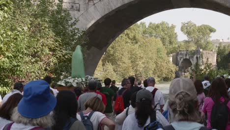 Religious-procession-in-Rome-along-the-banks-of-Tiber-river,-A-statue-of-the-madonna,-Mary,-the-mother-of-Jesus-Christ,-is-carried-by-4-men