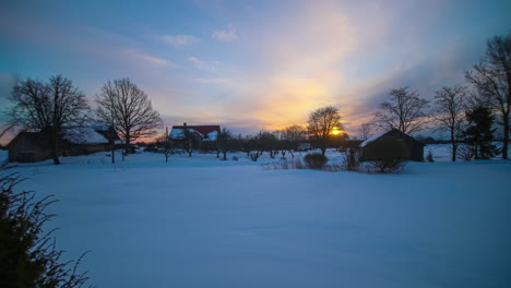 Sunrise-Over-Snowed-In-Landscape-with-Lodges-in-Countryside-Latvia,-Timelapse