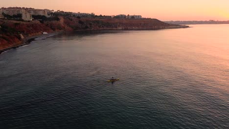Kayaker-rowing-at-sea-during-sunset