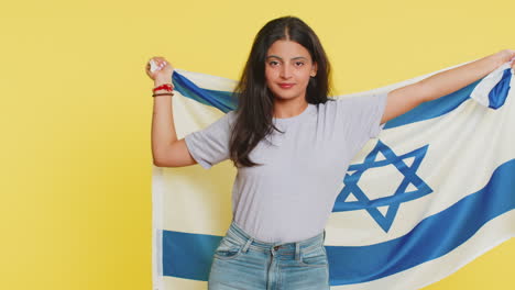 Indian-smiling-young-woman-holding-Israel-national-flag,-showing-victory-peace-sign-against-war