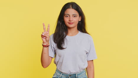 Happy-smiling-Indian-woman-girl-showing-victory-sign,-hoping-for-success-and-win-doing-peace-gesture