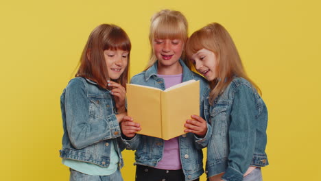 Three-girls-siblings-friends-reading-funny-interesting-fairytale-story-book,-leisure-hobby-education