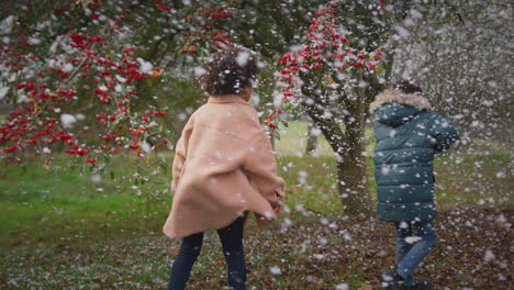 Two-children-having-fun-playing-in-snow-on-winter-walk-in-countryside---shot-in-slow-motion
