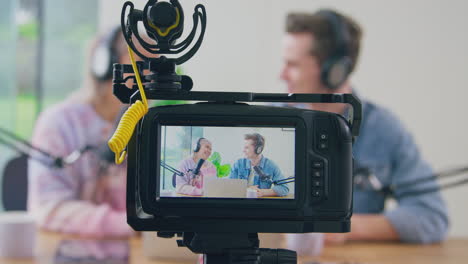 Blick-Durch-Die-Kamera-Auf-Ein-Paar-Mit-Kopfhörern,-Das-Live-Streaming-Vloggt,-Lacht-Und-Redet