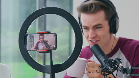 Male-Vlogger-Or-Influencer-Live-Streaming-Podcast-At-Home-Recorded-On-Mobile-Phone