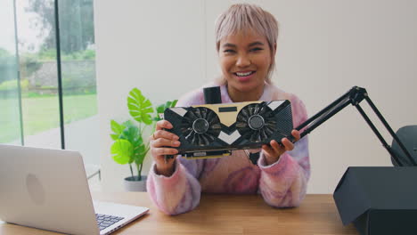 Female-Vlogger-With-Laptop-And-Microphone-Live-Streaming-Online-Electronics-Product-Review-To-Camera