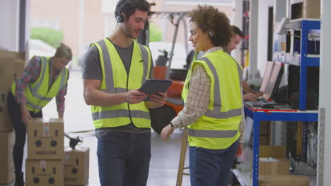 Männliche-Und-Weibliche-Arbeiter-Tragen-Headsets-Im-Logistikvertriebslager-Und-Nutzen-Ein-Digitales-Tablet