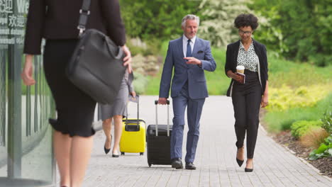 Group-Of-Business-Delegates-With-Luggage-Arriving-At-Conference-Hotel