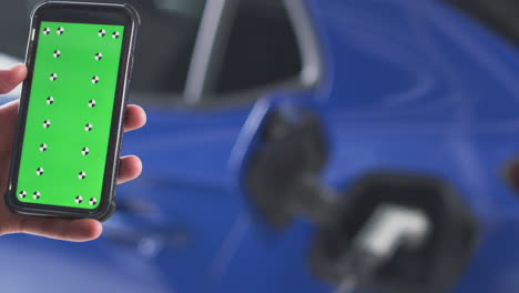 Mann-Lädt-Elektroauto-Mit-Kabel-über-Greenscreen-Telefon-Auf,-Um-Den-Batteriestand-Zu-überwachen