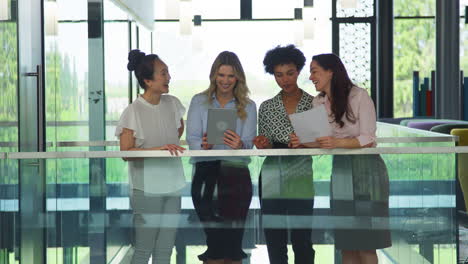 Multi-Cultural-Female-Business-Team-With-Digital-Tablet--Meeting-Inside-Modern-Office-Building