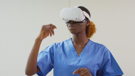 Female-Nurse-Or-Doctor-In-Scrubs-With-VR-Headset-Interacting-With-AR-Technology-In-Hospital