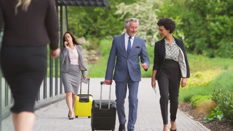 Group-Of-Business-Delegates-With-Luggage-Arriving-At-Conference-Hotel