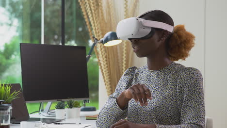 Woman-Working-From-Home-Office-At-Desk-Wearing-VR-Headset-Hosting-Virtual-Online-Meeting