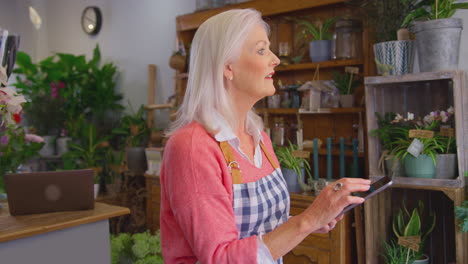 Mature-Female-Owner-Of-Florists-Shop-Using-Digital-Tablet-Receiving-Online-Order