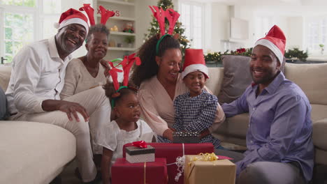 Mehrgenerationenfamilien-Feiern-Weihnachten-Zu-Hause-Mit-Weihnachtsmützen-Und-Geweihen-Und-öffnen-Geschenke