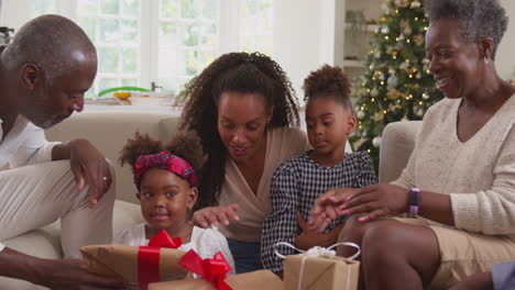 Mehrgenerationenfamilie-Feiert-Weihnachten-Zu-Hause-Und-öffnet-Gemeinsam-Geschenke