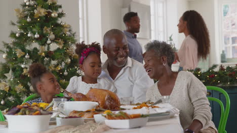 Familie-Mit-Mehreren-Generationen-Feiert-Weihnachten-Zu-Hause,-Während-Die-Eltern-Das-Essen-In-Der-Küche-Zubereiten