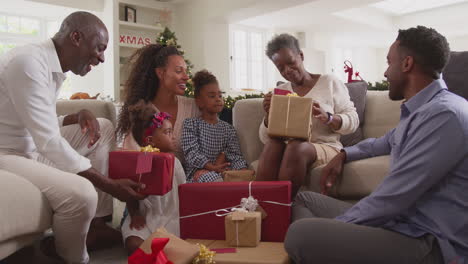 Familia-Multigeneracional-Celebrando-La-Navidad-En-Casa-Abriendo-Regalos-Juntos