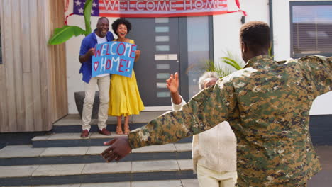 Multi-Generation-Family-With-Parents-And-Wife-Welcoming-Army-Soldier-Home-On-Leave-With-Banner