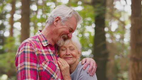 Liebevolles-älteres-Ehepaar-Im-Ruhestand,-Das-Sich-Gemeinsam-Auf-Einem-Spaziergang-In-Der-Waldlandschaft-Umarmt