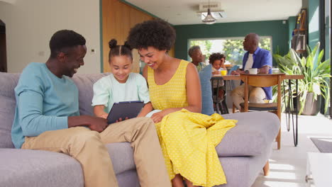 Mehrgenerationenfamilie-Mit-Eltern,-Die-Ein-Digitales-Tablet-Mit-Mädchen-Nutzen,-Und-Großeltern-Helfen-Enkel