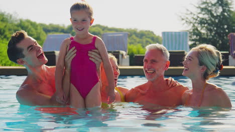 Lächelnde-Mehrgenerationenfamilie-Im-Sommerurlaub,-Die-Sich-Im-Schwimmbad-Entspannt