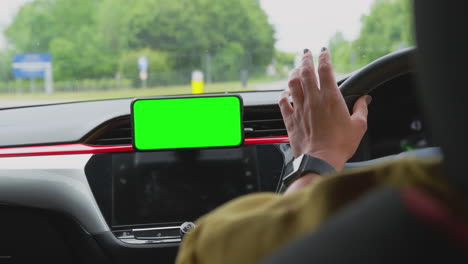 Nahaufnahme-Einer-Fahrerin-Mit-Freisprecheinrichtung-Für-Mobiltelefon-Mit-Grünem-Bildschirm,-Die-Auf-Dem-Armaturenbrett-Montiert-Ist