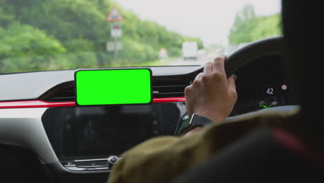 Close-Up-Of-Female-Driver-With-Hands-Free-Unit-For-Green-Screen-Mobile-Phone-Mounted-On-Dashboard