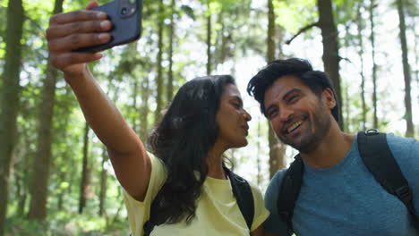 Paar-Macht-Selfie-Mit-Dem-Handy-Beim-Wandern-Oder-Spazierengehen-Durch-Die-Sommerliche-Waldlandschaft