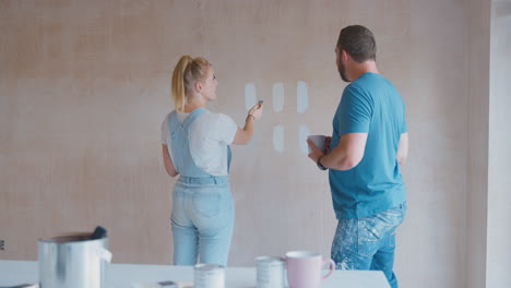 Couple-Renovating-Kitchen-At-Home-Painting-Tester-Paint-Colour-Strips-On-Wall