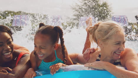 Lächelnde-Mehrgenerationenfamilie-Im-Sommerurlaub,-Die-Sich-Im-Schwimmbad-Auf-Der-Luftmatratze-Entspannt