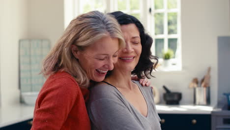Close-Up-Of-Loving-Same-Sex-Mature-Female-Couple-Doing-Washing-Up-In-Kitchen-Together