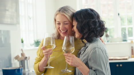 Liebevolles-Gleichgeschlechtliches-Reifes-Weibliches-Paar,-Das-Zu-Hause-Gemeinsam-Mit-Einem-Glas-Wein-Feiert
