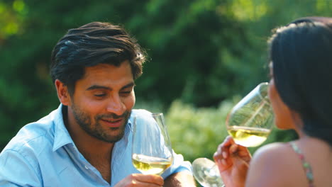 Couple-Outdoors-Drinking-Wine-In-Summer-Garden-At-Home-Together