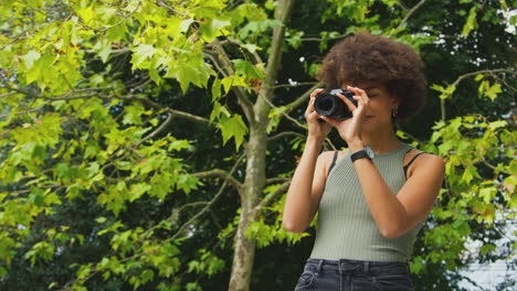 Frau-Draußen-Mit-DSLR-Kamera,-Die-Im-Sommer-Fotos-Im-Stadtpark-Macht