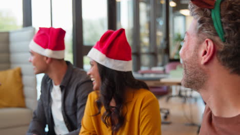 Staff-Celebrating-With-Christmas-Party-In-Office-Dressing-Up-Wearing-Reindeer-Antlers-And-Santa-Hat