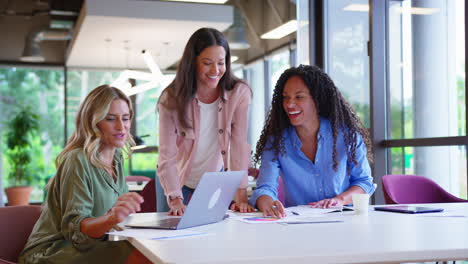 Multikulturelles-Weibliches-Geschäftsteam-Sitzt-Am-Schreibtisch-Mit-Laptop-Im-Büro-Und-Arbeitet-An-Einem-Projekt-Zusammen